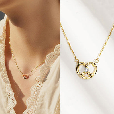 Gold open heart necklace worn on model next to white-background close-up