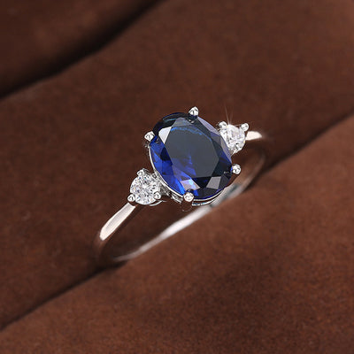 Silver blue oval three-stone ring on brown velvet