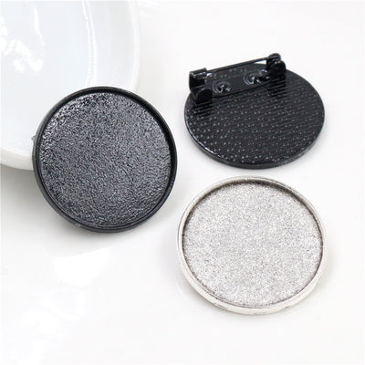 Round Brooch Bezel Settings in Black and Antique Silver assortment on a plain background