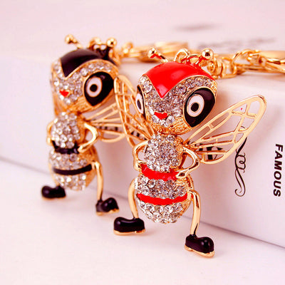Red and black stone-covered bee keychains displayed together.