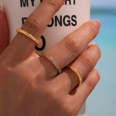 Gold triple band zircon ring worn on middle finger with two plain bands