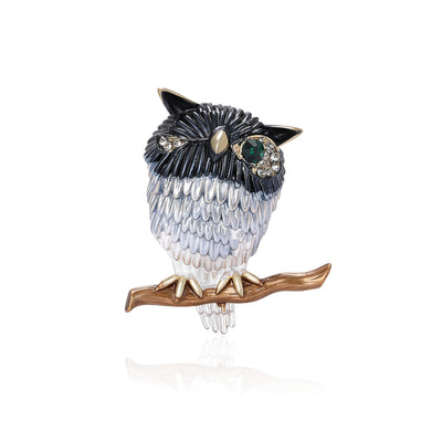 Front view of the single eye metal owl on branch brooch in brown and blue brooch and its color options