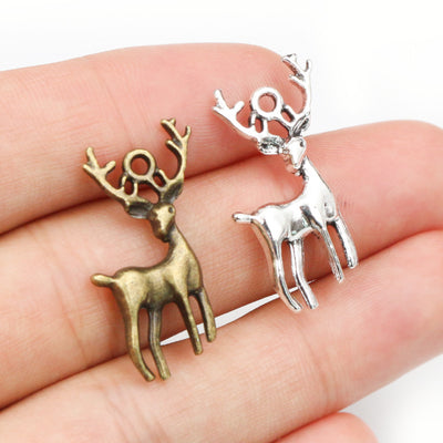 Hand held view of the standing stag charms with antlers showing the front shape and finish