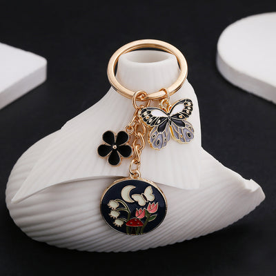 Main display of black or pink butterfly flower and mushroom keychains