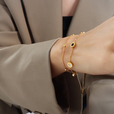 Wrist wearing gold double-layer shell and black disc bracelet