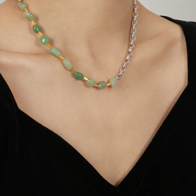 Green stone and silver chain necklace worn on collarbone