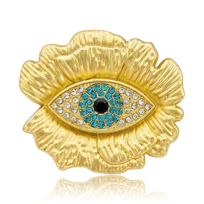 Front view of turquoise blue eye centered on a textured gold tone floral shape