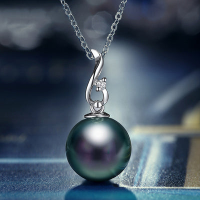 Dark peacock pearl pendant on silver chain with bokeh blue background