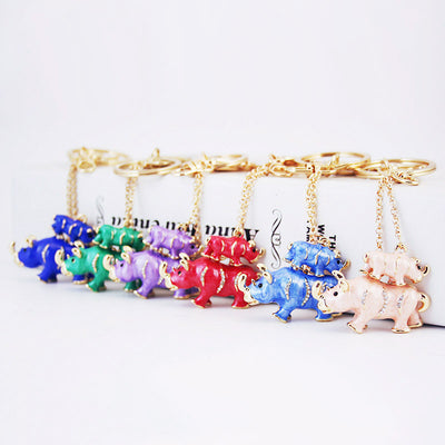 Multiple colorful rhinoceros pair keychains arranged in a row with gold-tone hardware.