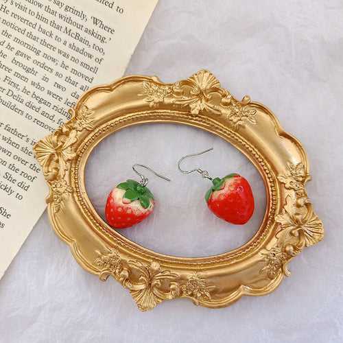 Strawberry fishhook earrings inside ornate gold frame
