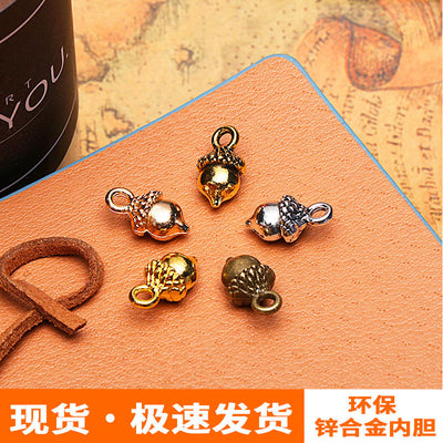 Assorted small acorn charms in several metal finishes