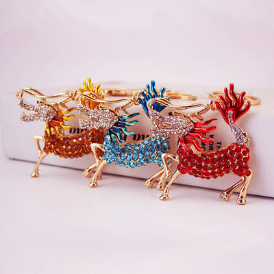Three rhinestone Qilin keychains in golden yellow, blue, and red.