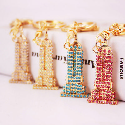 Four gold-tone Eiffel Tower keychains decorated with different colored rhinestones.