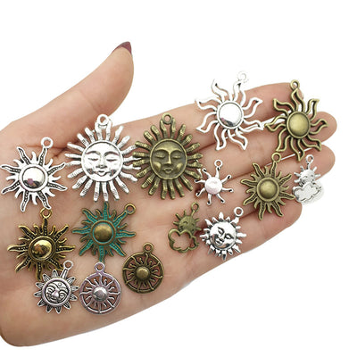 Antique silver sun and moon charms arranged on a light background