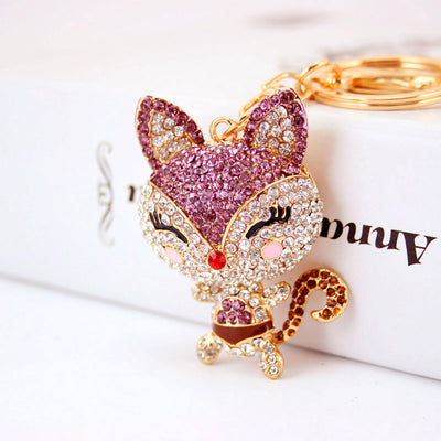 Close-up of a purple rhinestone fox charm attached to a gold-tone keyring.