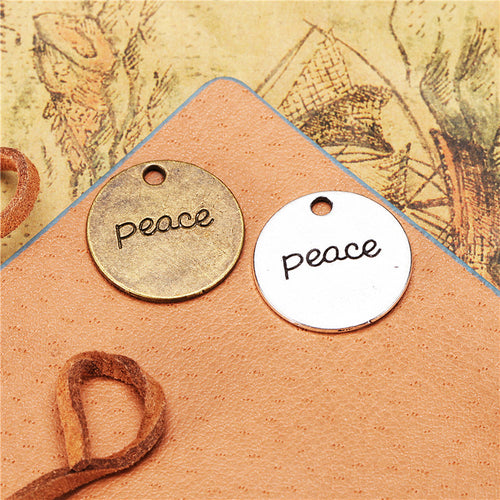 Alternate view of the two-sided peace disc charm showing its raised and recessed details