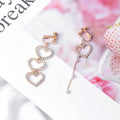 Clear Look Triple Heart Asymmetric Clip Earrings in Two Finishes view 6