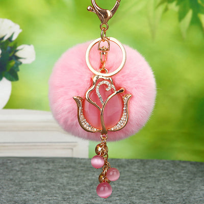 A styled product view shows the tulip pom pom keychain and attached key hardware.
