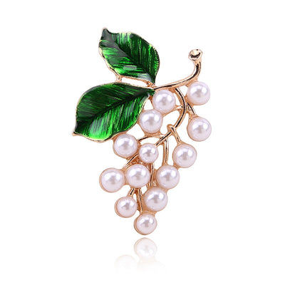 Front view of the green leaf grape cluster brooch with pearls with polished metal detail on a white background