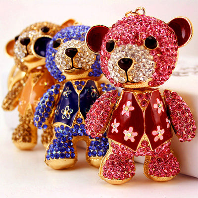 Three rhinestone bear keychains in pink, blue, and brown stand in a row.