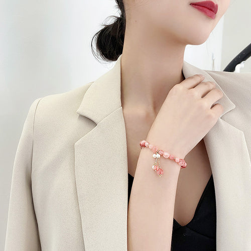 pink beaded stretch bracelet with three dangle charms in a second styled product view