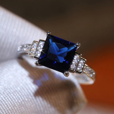 Product view showing silver-tone deep-blue square solitaire geometric ring
