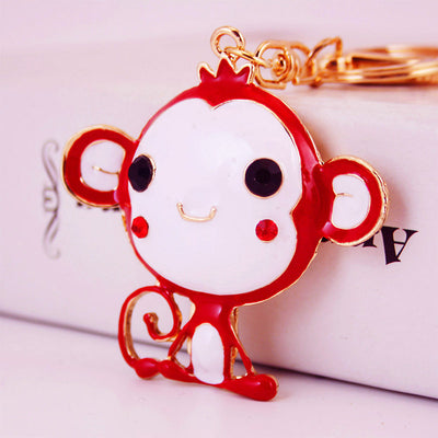 Close view of a red monkey charm attached to gold-tone keychain hardware.