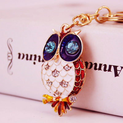 Close-up of the owl charm showing red side panels and blue faceted eyes.