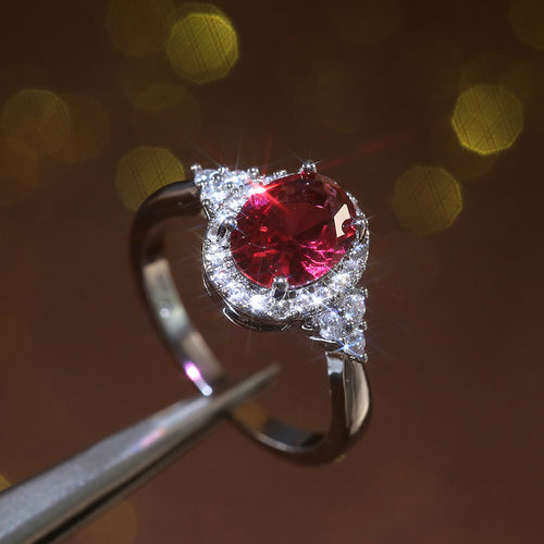 Second product view showing silver-tone red oval halo three-stone ring