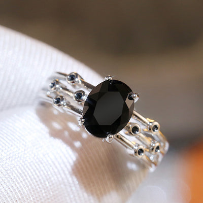 Product view showing silver-tone black oval solitaire multi-rail ring