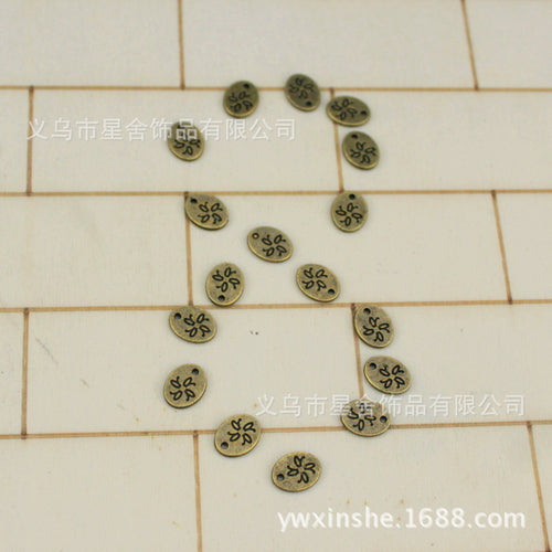 Mixed tiny oval flower charms arranged on a tiled surface