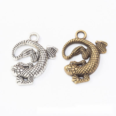 Curled lizard metal component, grouped front view on white
