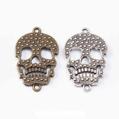 Assorted skull connectors arranged together on a white background
