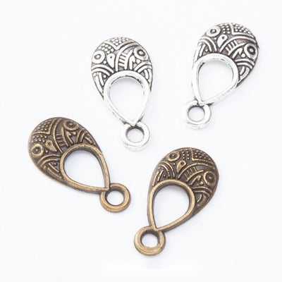 engraved teardrop openwork metal charms in two finishes shown together in the available finishes