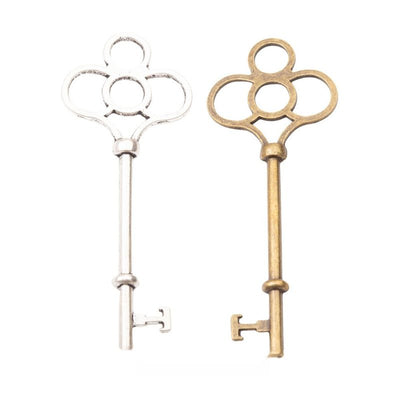Grouped front view of ornate key charm showing a four-loop bow and notched bit