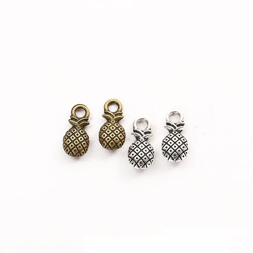Assorted antique bronze and antique silver tiny textured pineapple charm pieces on white