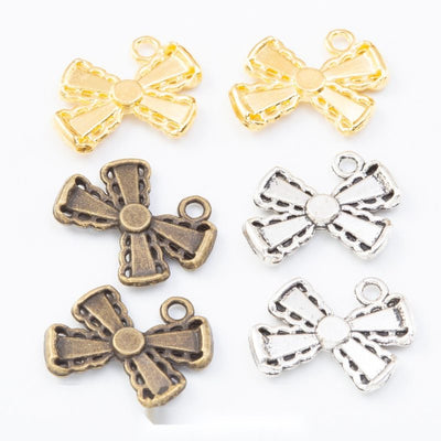 Group view of the bow charm showing the available finishes and front details