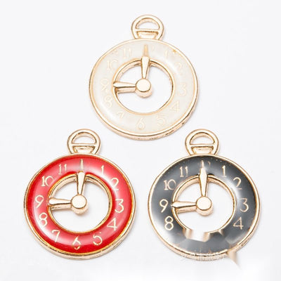 Assorted enamel clock charms arranged together on a white background