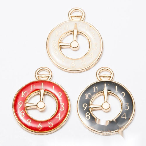 Assorted enamel clock charms arranged together on a white background