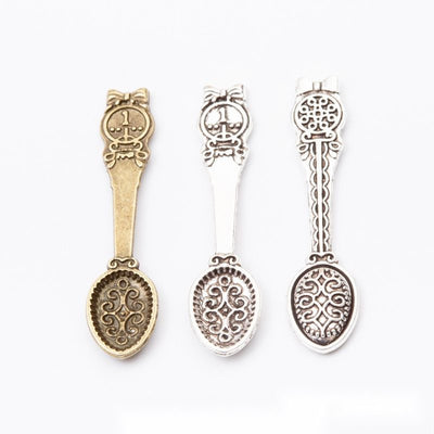 Grouped front view of ornate spoon charms in the available finishes