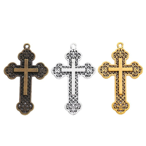 Overview of ornate cross charm pieces on a white background