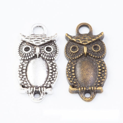 Grouped front views of the owl oval bezel tray connector in two antique finishes
