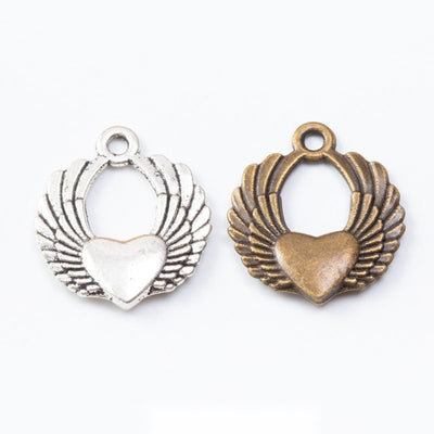 Product photo 1 of the winged heart wreath charm highlighting its central heart framed by feathered wings and a round op