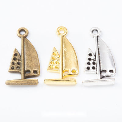 Finish comparison of 帆船 charm on a white background