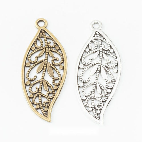 Assorted antique bronze and antique silver openwork filigree leaf charm pieces on white