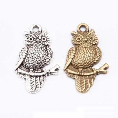 Assorted antique bronze and antique silver detailed perched owl charm pieces on white