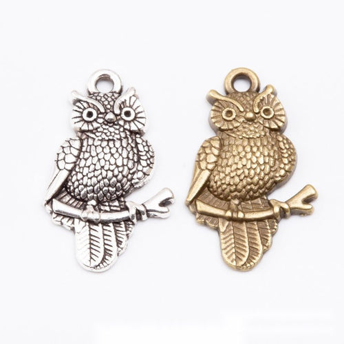Assorted antique bronze and antique silver detailed perched owl charm pieces on white
