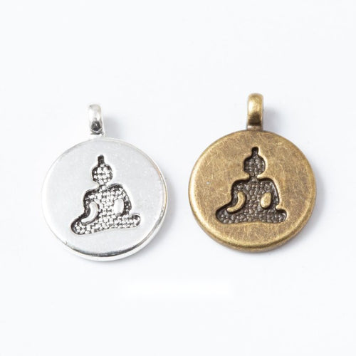 round seated yoga figure metal charms in two finishes shown together in the available finishes
