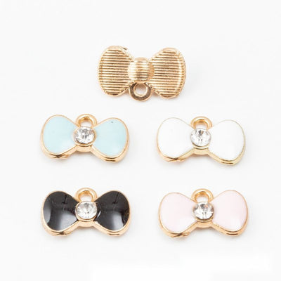 Four enamel bow colors with gold-tone outlines and clear center stones