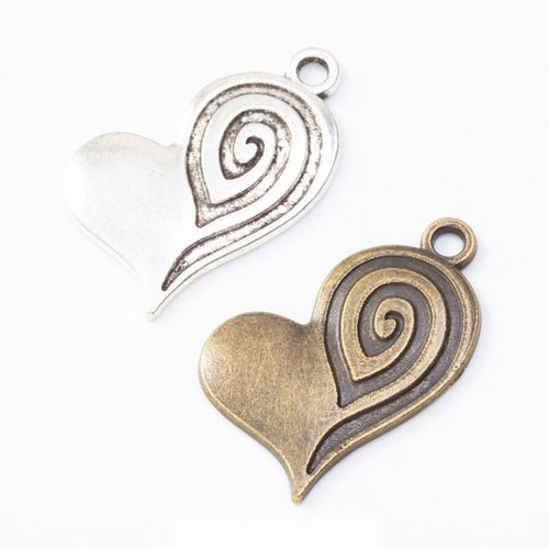 textured swirl heart metal charms in two antique finishes shown together in the available finishes